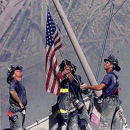 Firefighters raising American flag